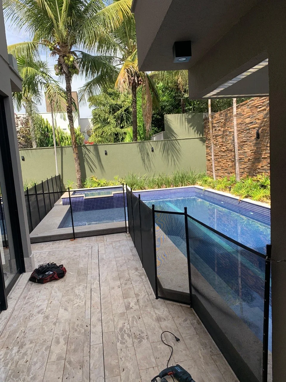 Cerca removível acompanhando uma piscina residencial comprida
