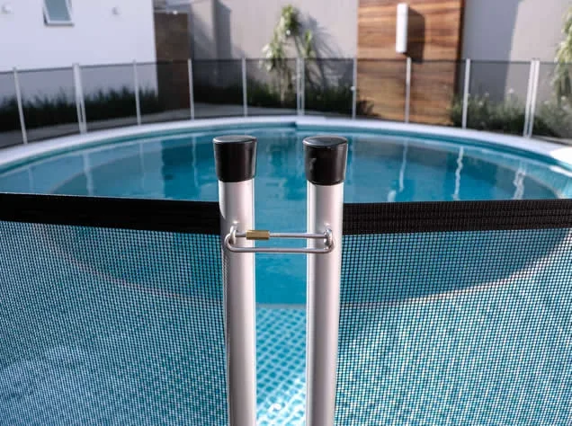 Detalhe dos postes e da união entre módulos da cerca junto à piscina